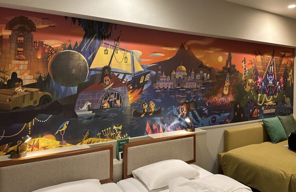 リニューアル前のディスカバー客室に描かれた冒険をテーマにした壁画とベッド、ソファ