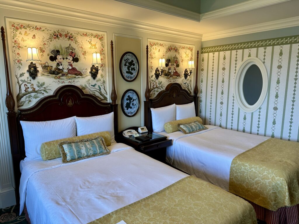 東京ディズニーランドホテルのスタンダードルームにある2台のベッドとディズニーキャラクターの壁面装飾